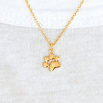18k gold Teeny Tiny Paw Neckace on t-shirt